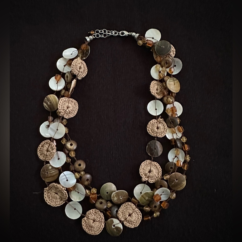 Unique mixed materials necklace with shells, beads and small crocheted disks.